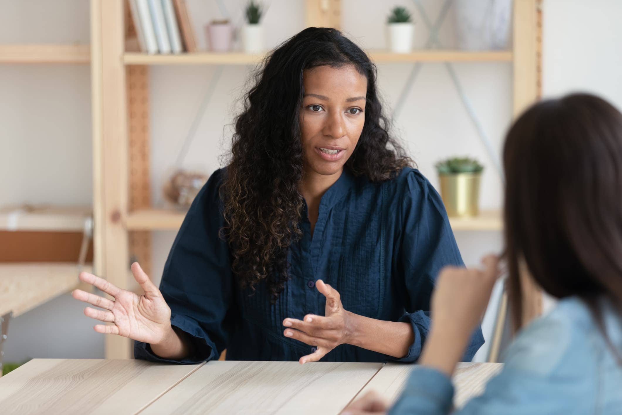 Confident african american businesswoman explaining new responsibilities to female applicant