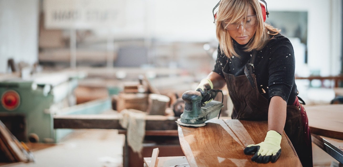 Carpenter polishing wooden panel