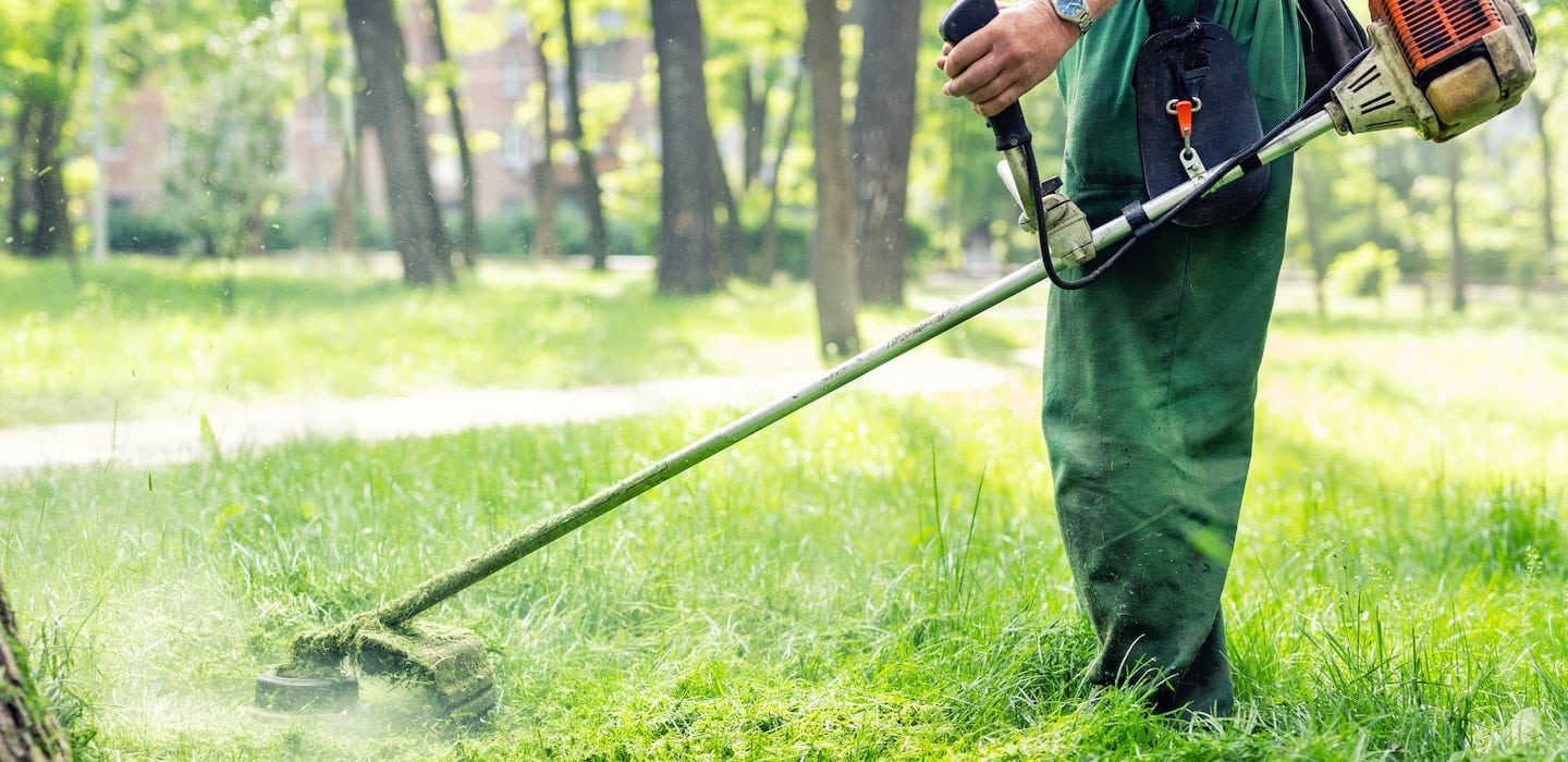 landscaper mowing tall grass