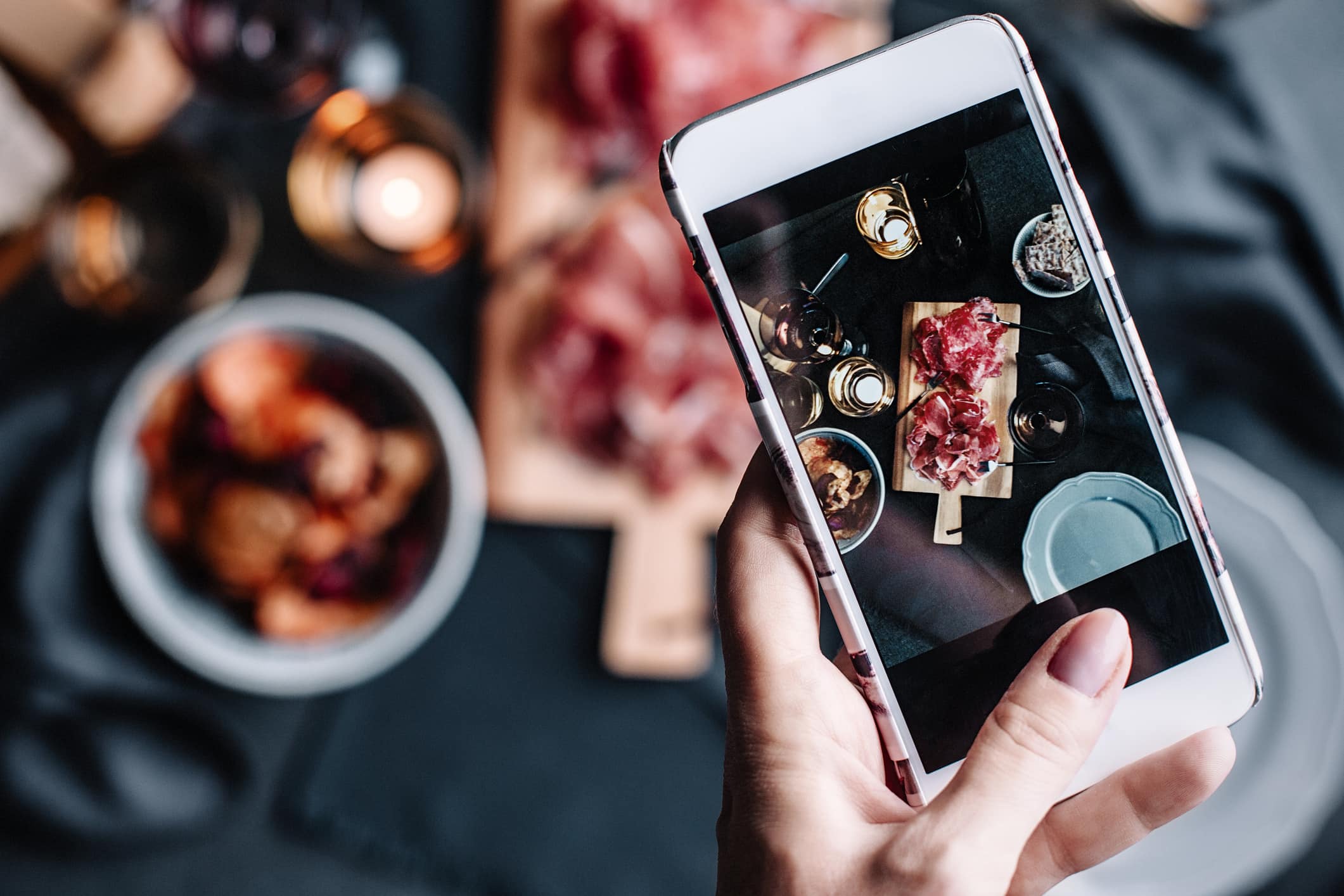 Mobile phone taking photos of food on the table.