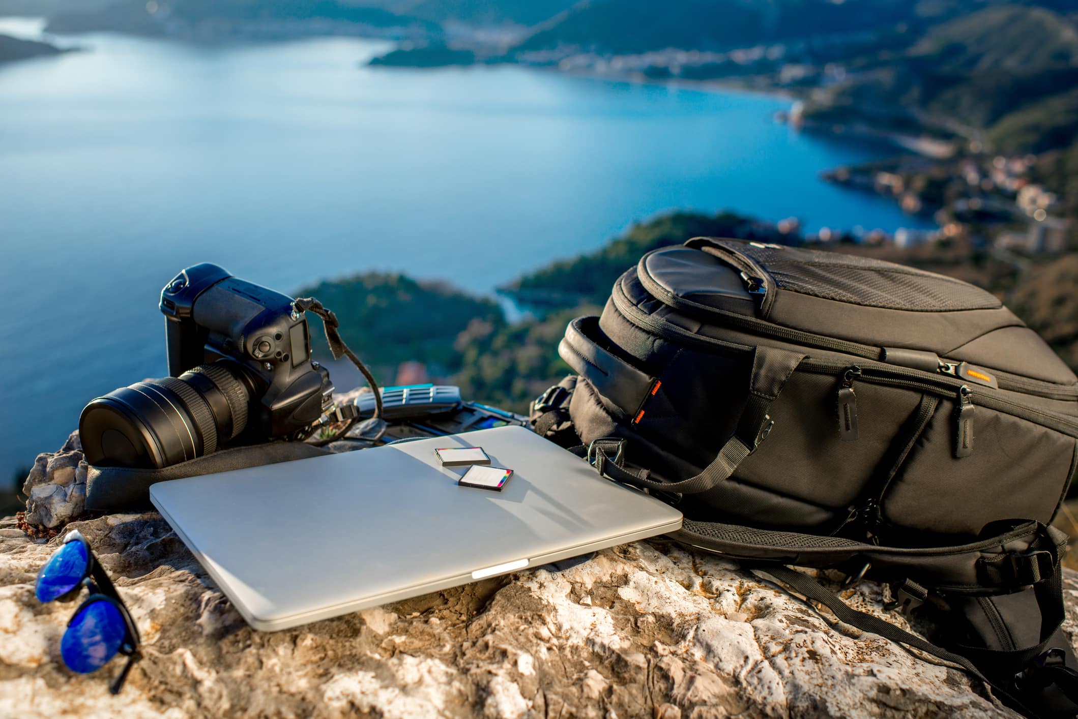 Travel photographer equipment on rocky mountain with beautiful landscape on the background