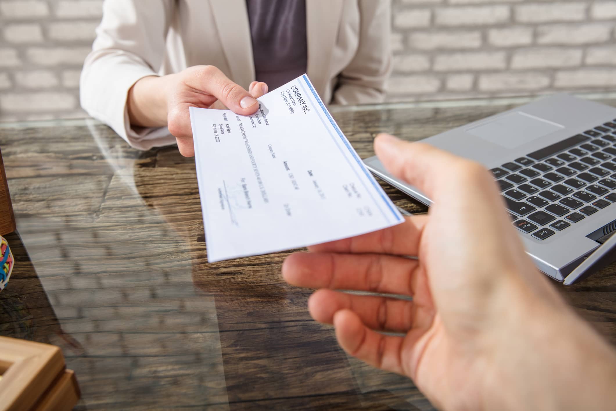 Businesswoman Giving Cheque To Her Colleague