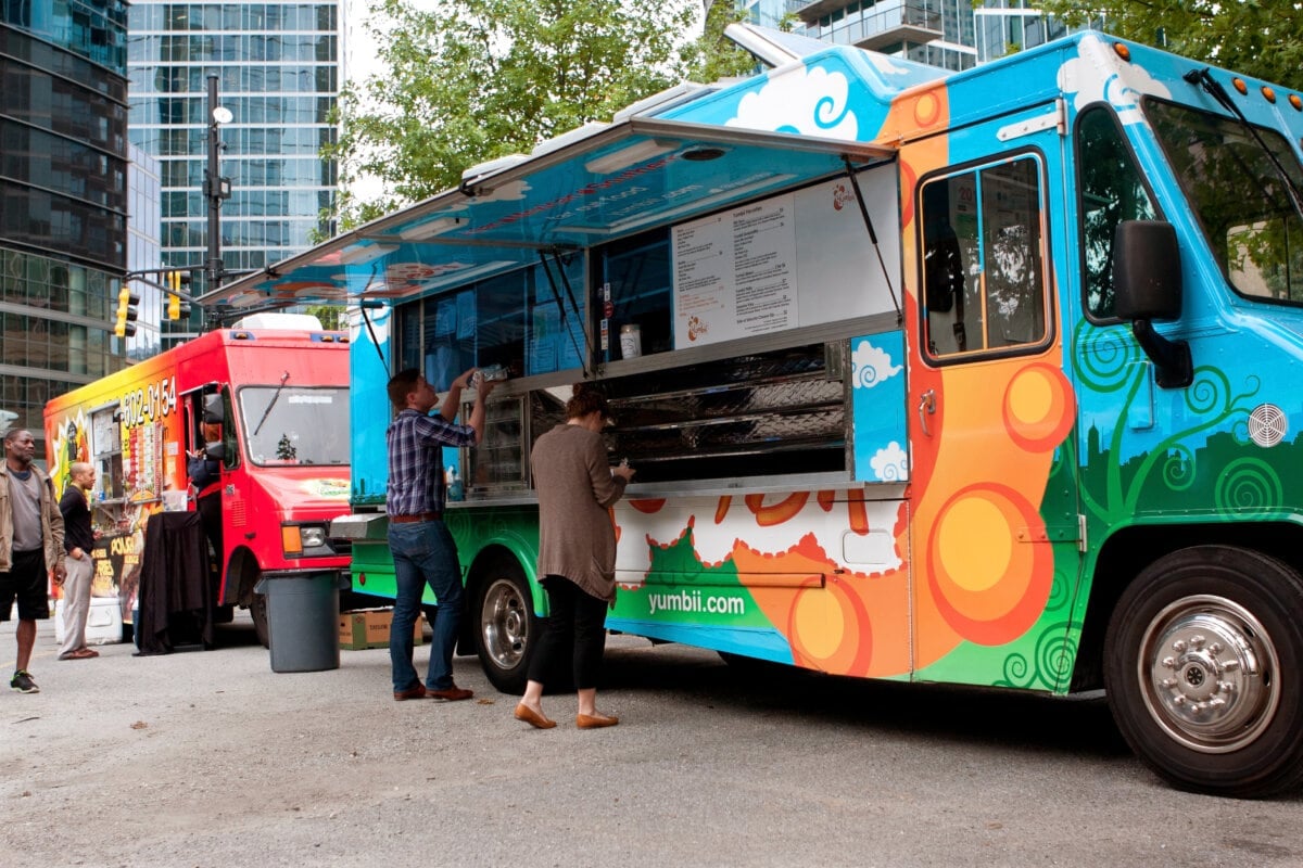 Customers order meals from a popular food truck during their lunch hour, at 