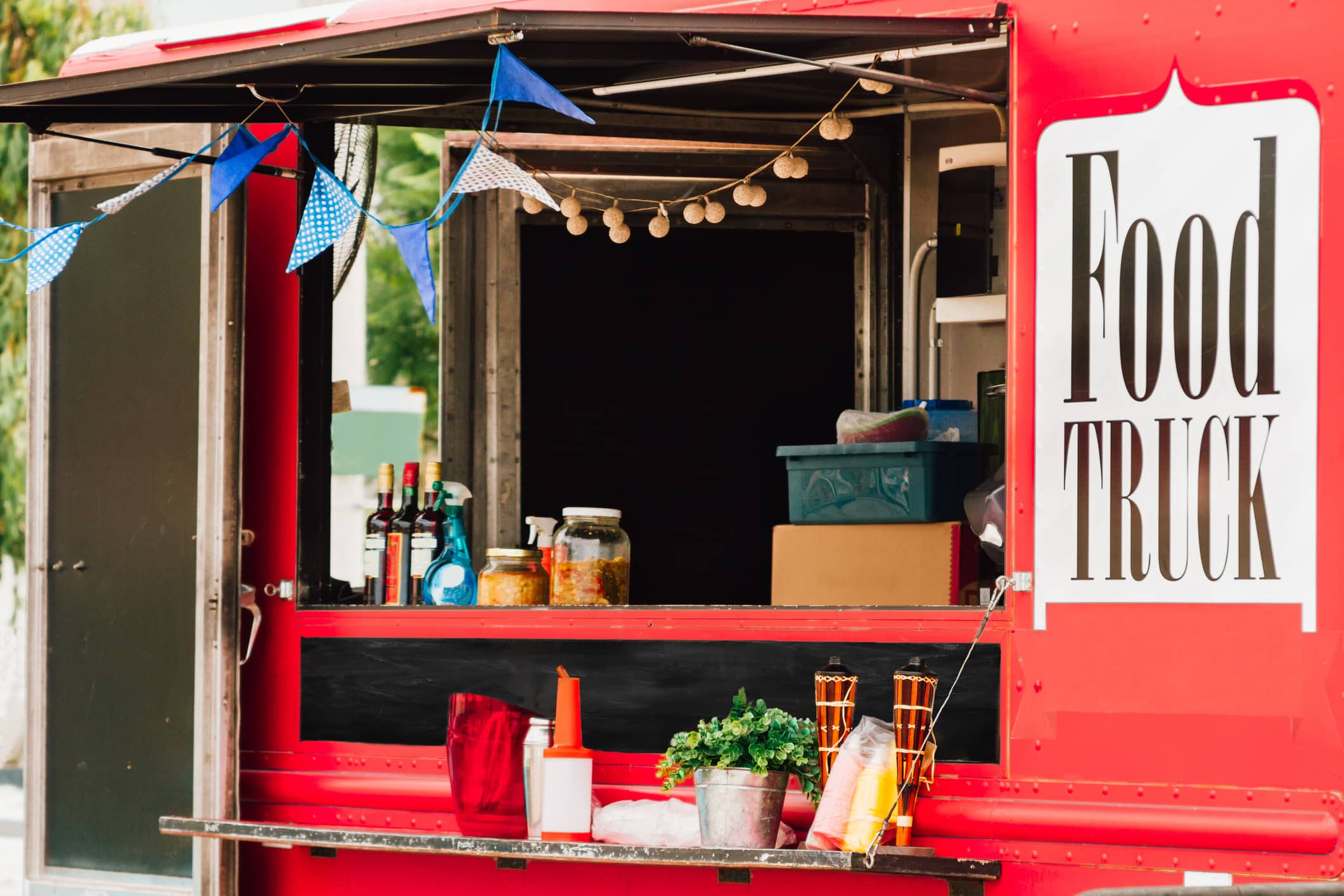 Window selling of a red food truck with pennants.