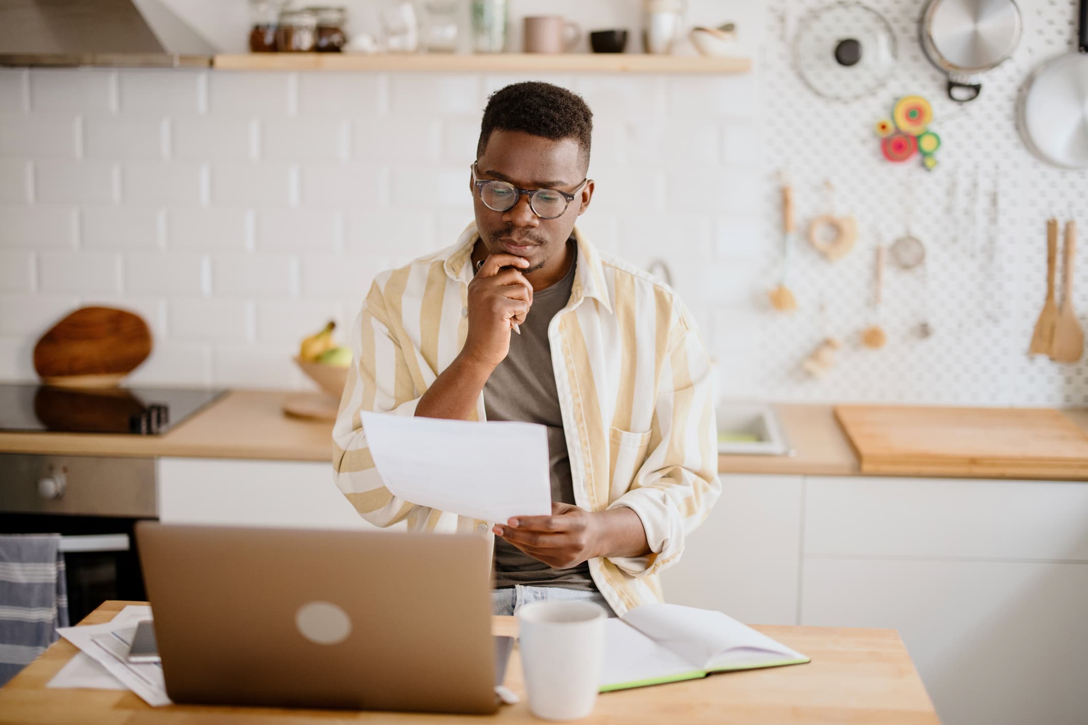 Man calculates personal income by using laptop and online banking on smartphone.