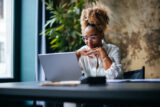 Smiling Businesswoman Using A Laptop Computer In The Cafe