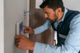 Technician installing an alarm system in a smart home