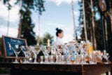 Rows of empty cocktail glasses on a table at an outdoor event