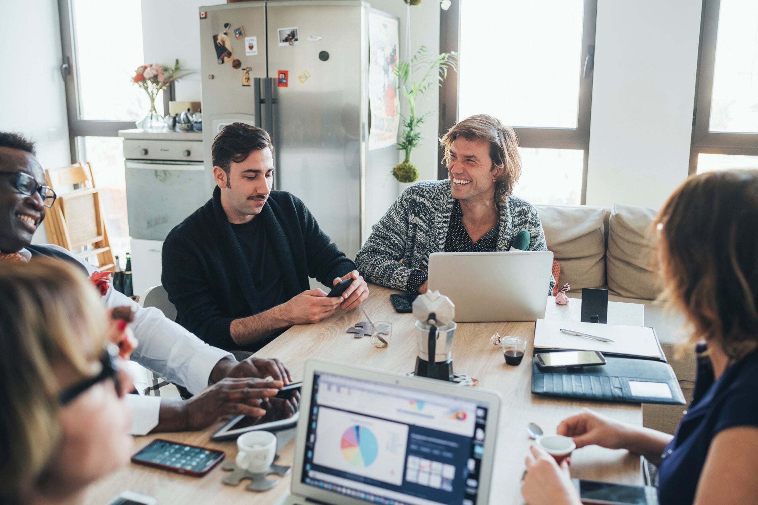 Smiling coworkers collaborate around a table