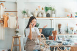 Young woman talks on phone in shop